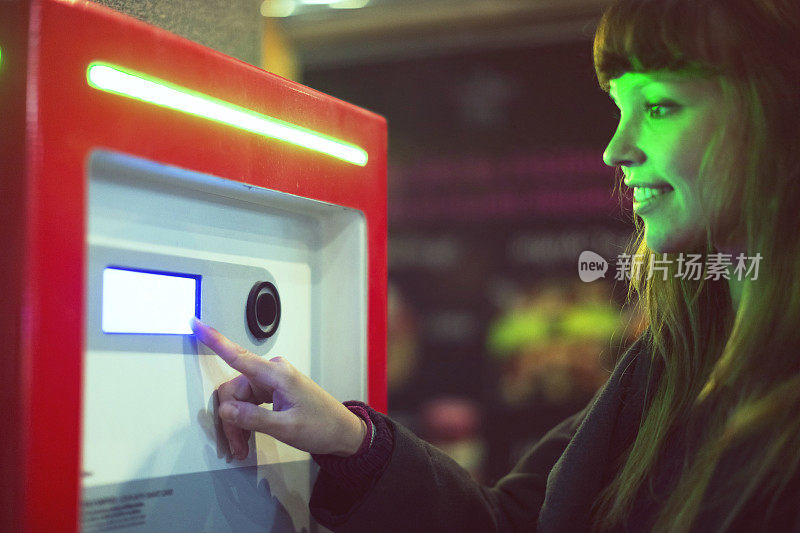 Young woman using urban info and tickets machine